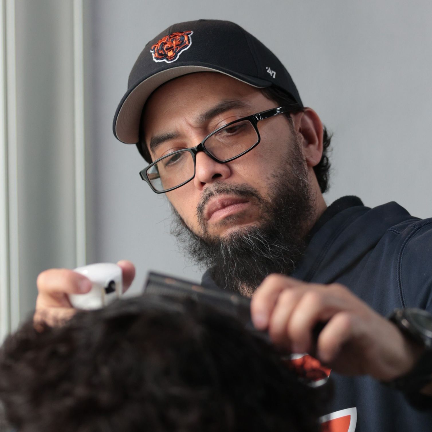 Jose working with clippers at International Barbershop