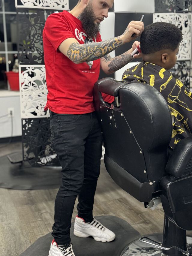 Precision haircut being completed inside International Barbershop